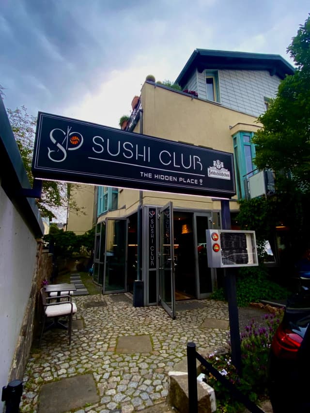 Außenansicht des Sushi Club Radebeul mit großer Beschilderung, Restaurantfassade und einladendem Eingangsbereich auf Kopfsteinpflaster